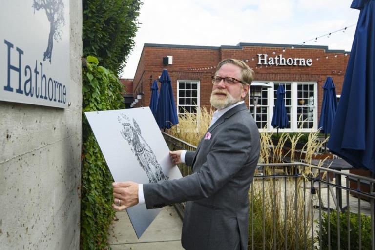 restaurant owner holds a sign for a pop-up restaurant